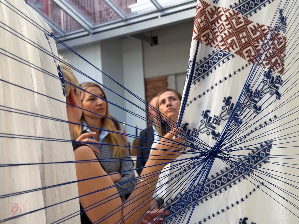 Visitors looking at the installation through the blue threads, The Gorj. Constantin before Brâncuși