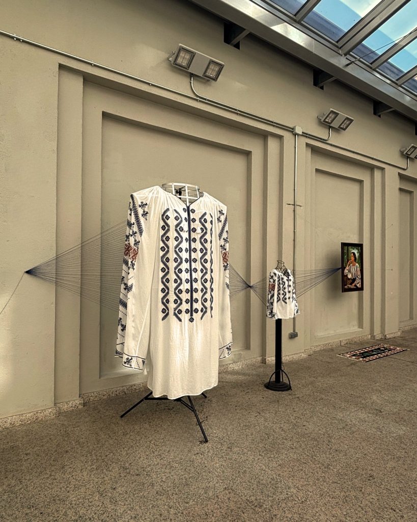 Monumental hand-sewn ie with Gorj embroidery, linked by blue threads to a wearable ie
