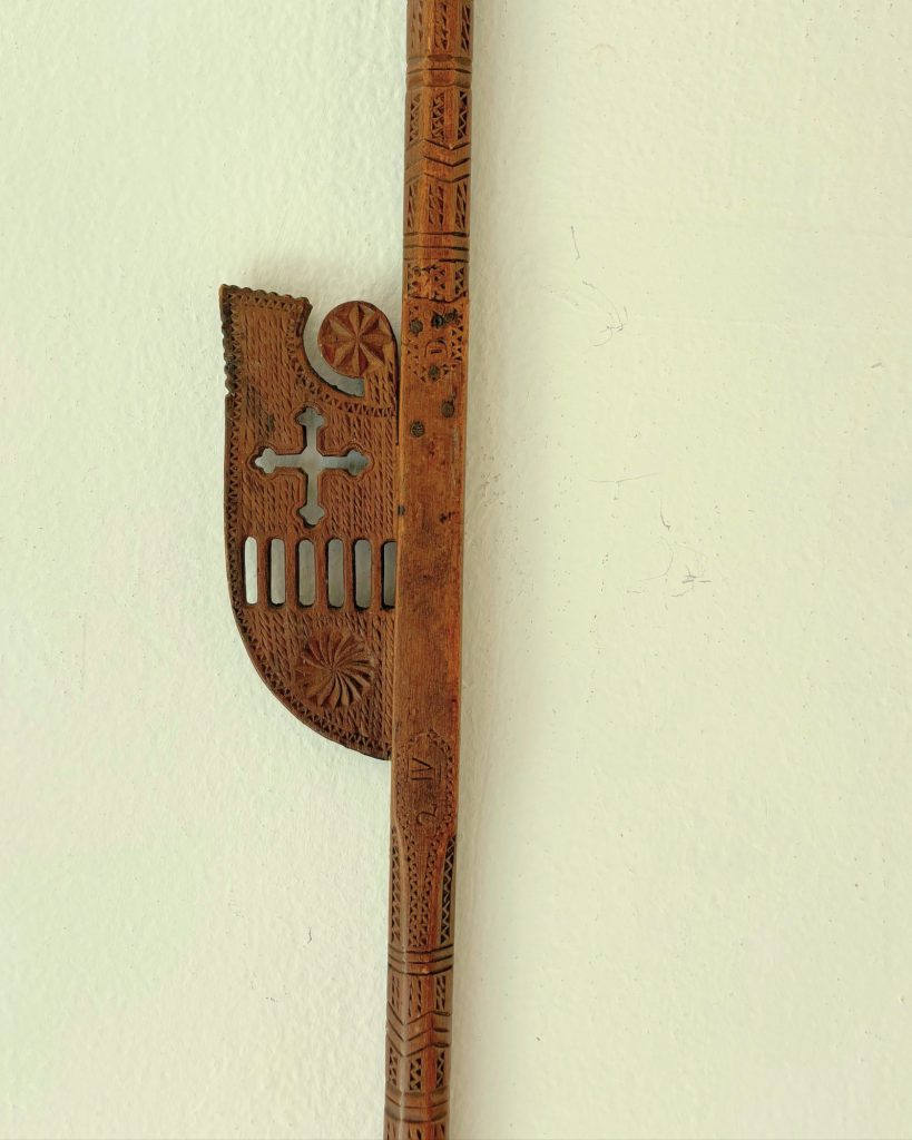 Spinning distaff with a perforated cross, vertical openings and a radial rosette