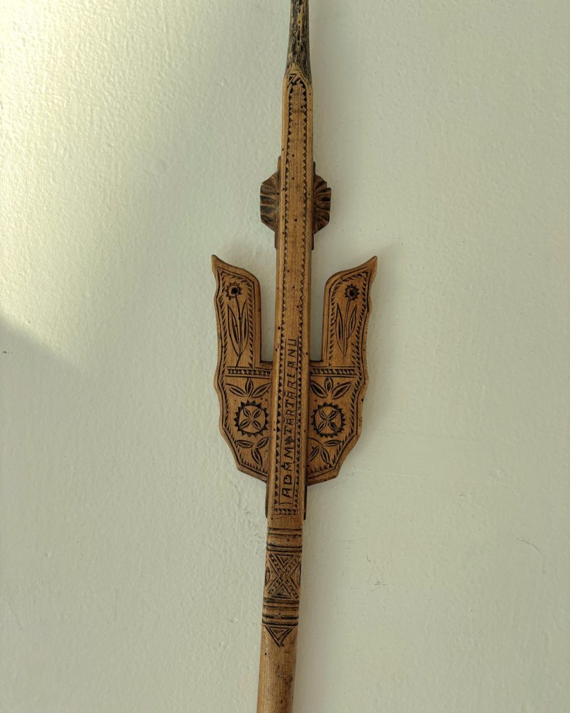 Richly carved spinning distaff with floral motifs and an inscription