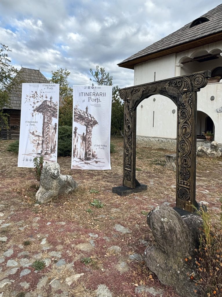 Carved wooden gate and exhibition banners at the Curtișoara museum