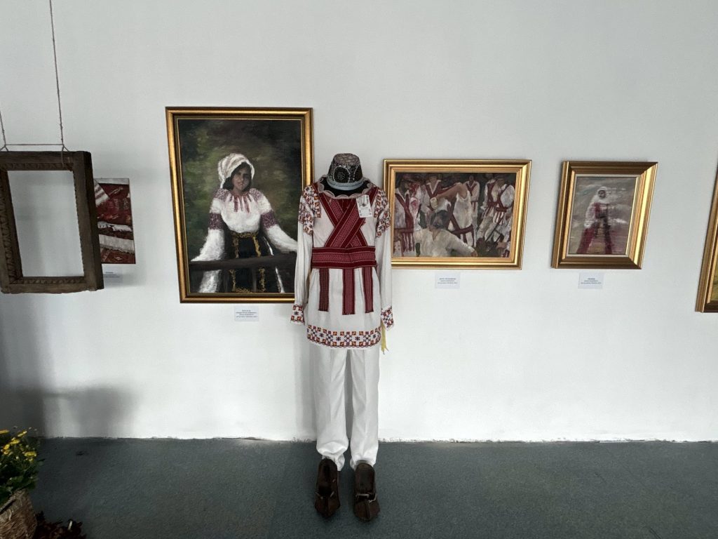 Călușar costume between paintings by Diana Marinescu