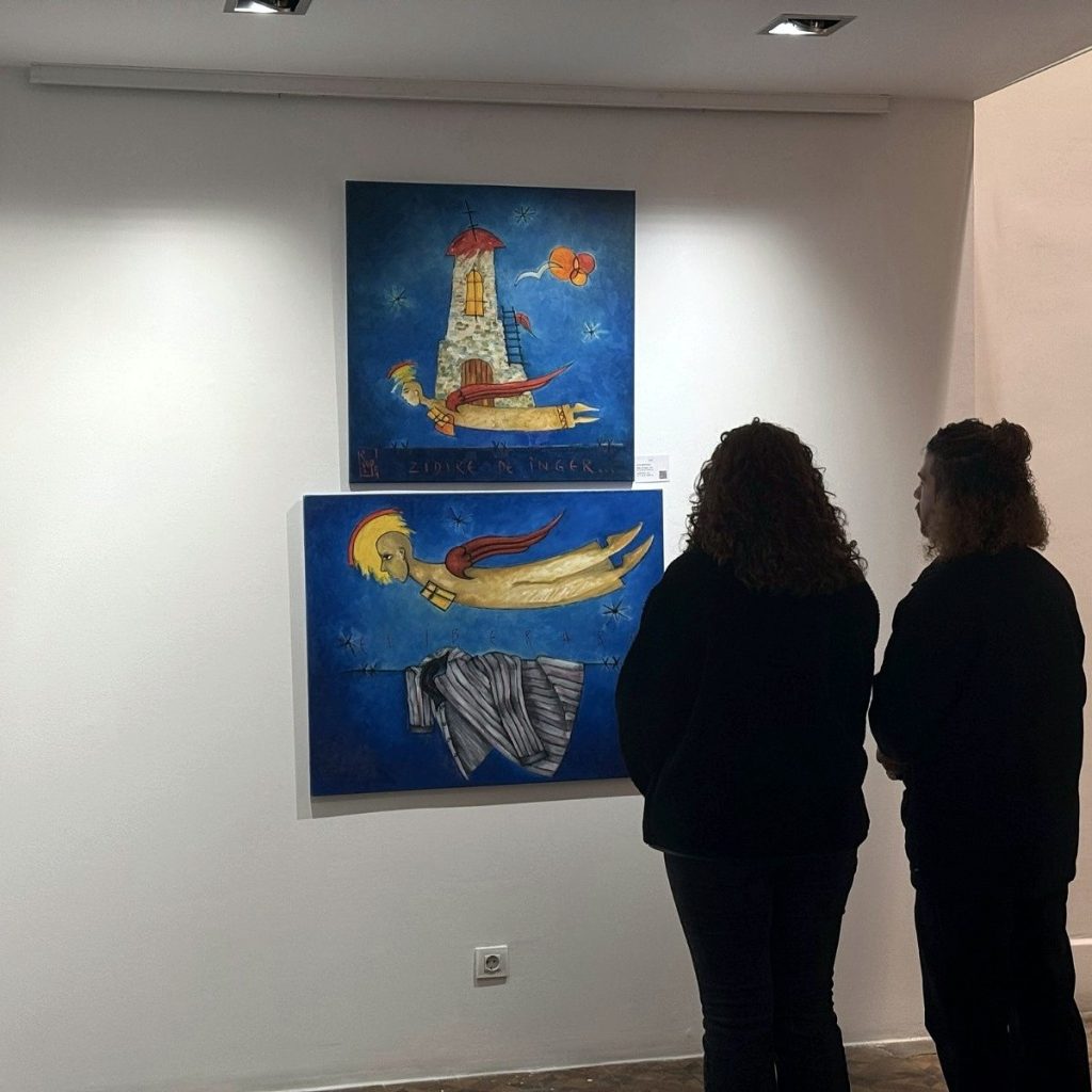 Visitors looking at two paintings on a blue background